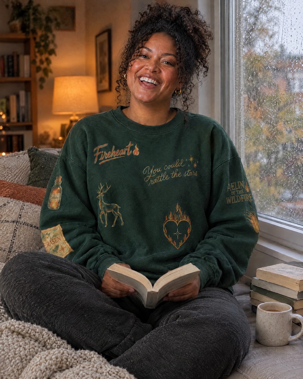 Aelin Fireheart Doodles Sweatshirt, by a rainy window with a book