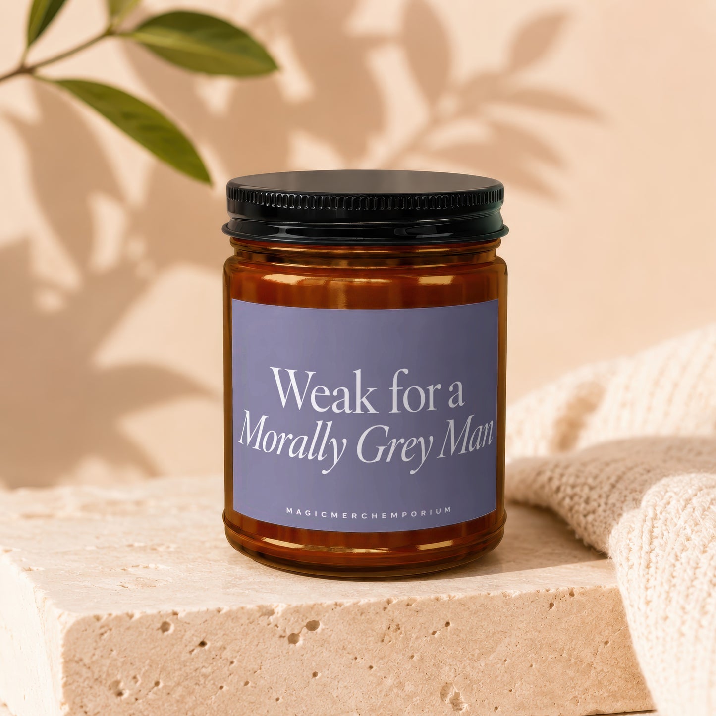 Amber jar candle with purple label reading "Weak for a Morally Grey Man"