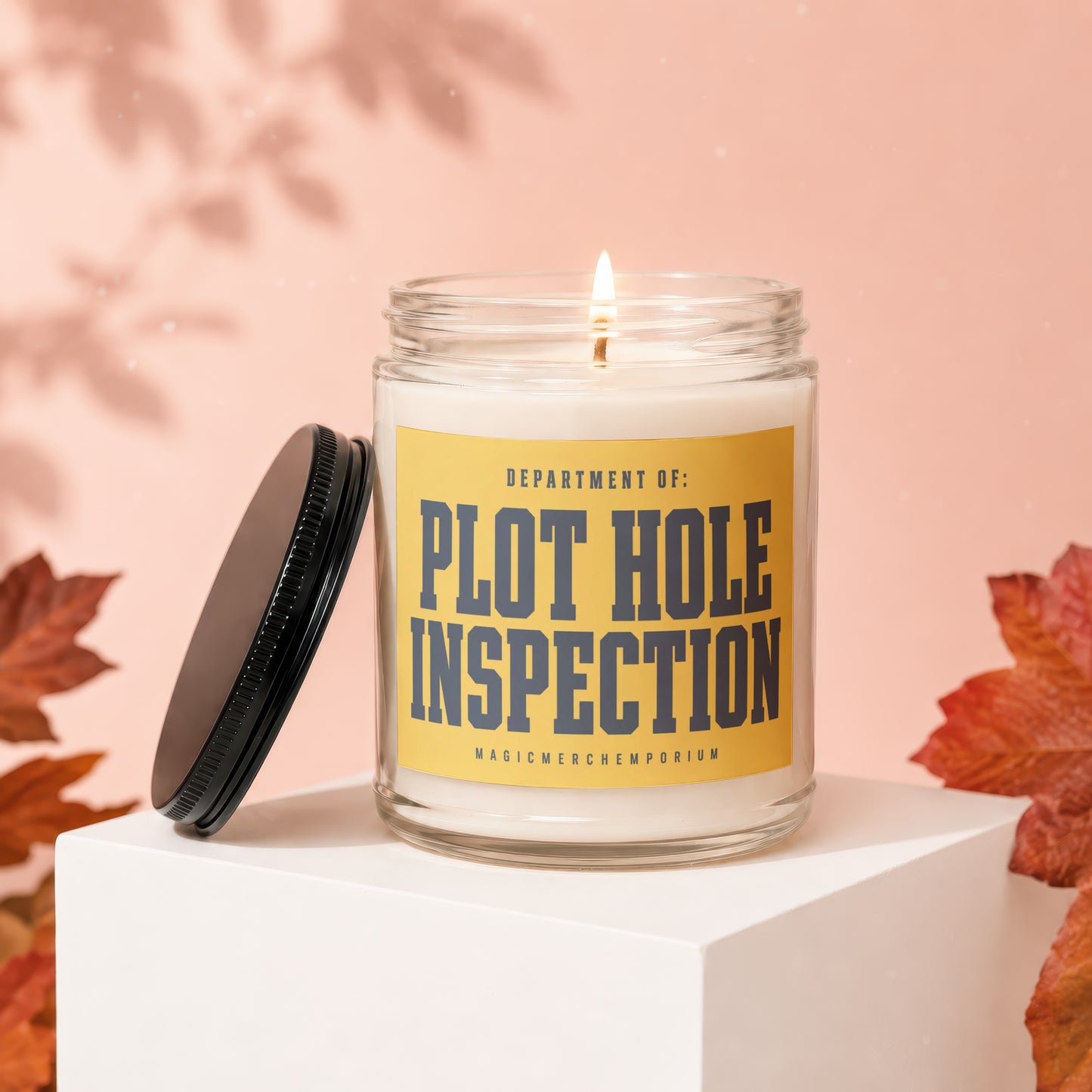 Candle with "Department of: Plot Hole Inspection" label and a lit wick.