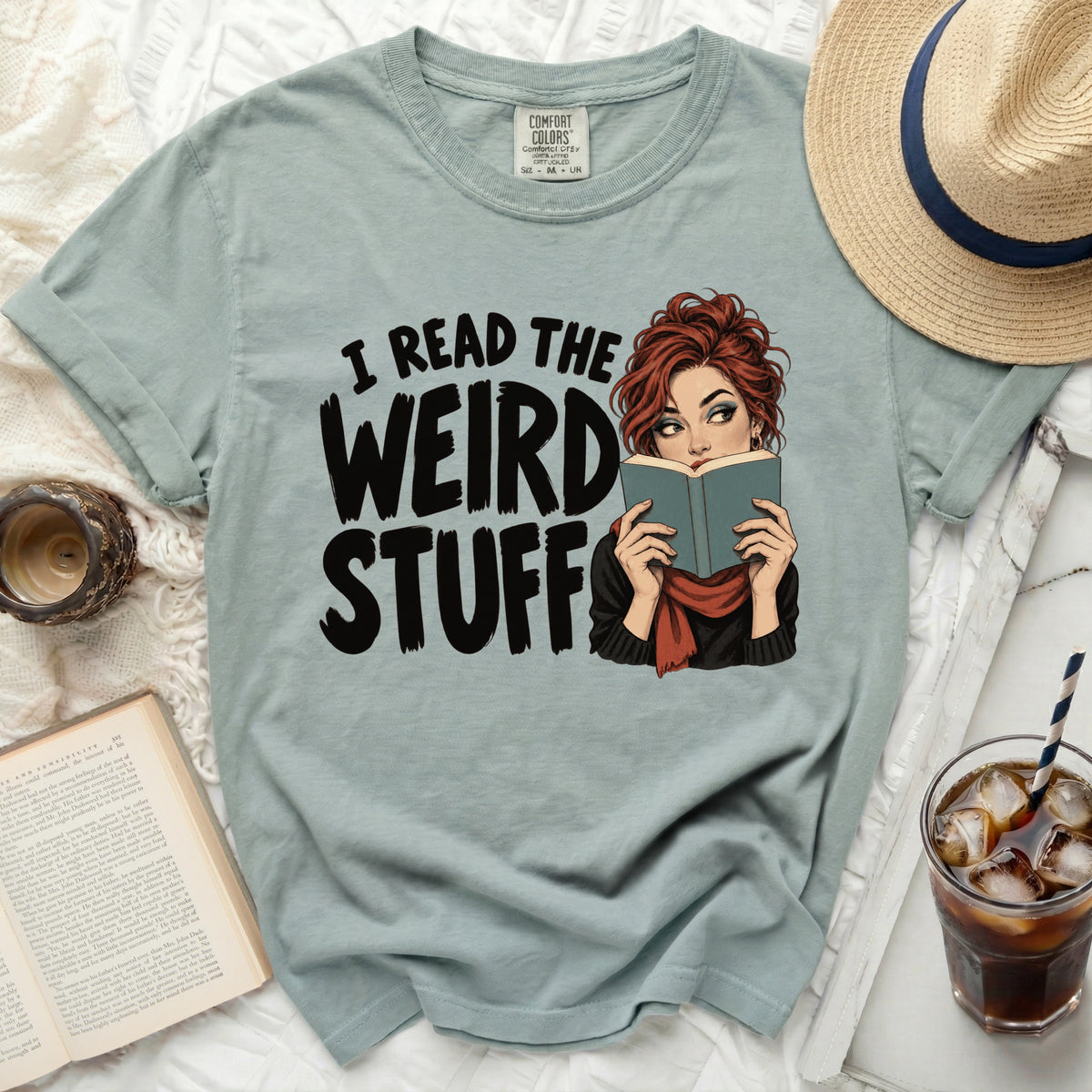 T-shirt with graphic reading "I READ THE WEIRD STUFF" featuring a woman reading a book.