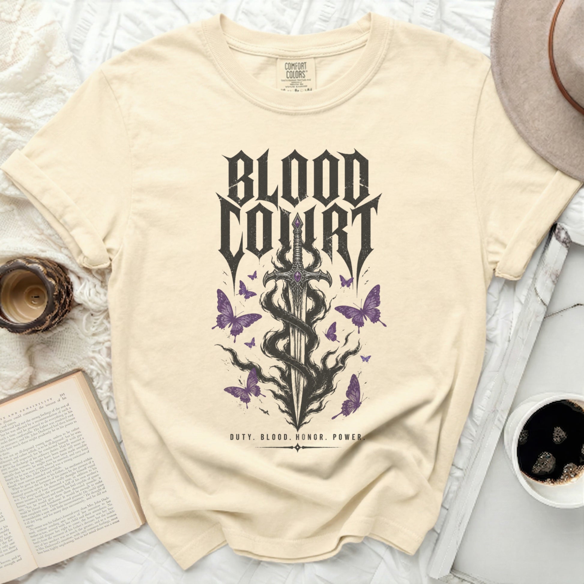 Cream t-shirt with gothic sword, butterflies, and "Blood Court" text.
