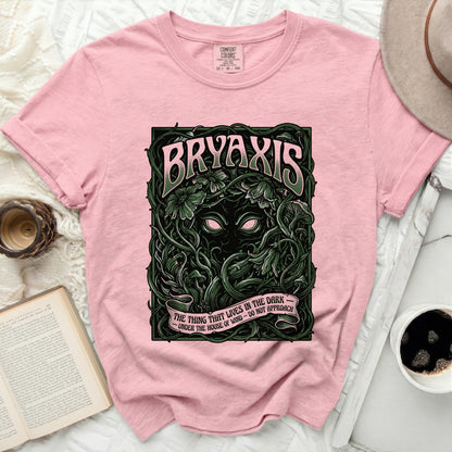 Pink t-shirt with "BRYAXIS" and "THE THING THAT LIVES IN THE DARK" text.