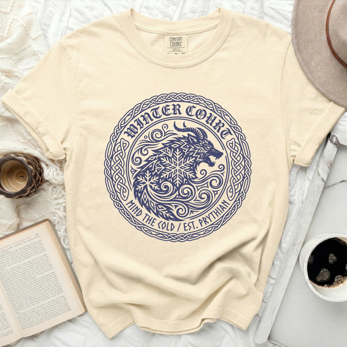 Cream t-shirt with a navy blue circle graphic of a wolf and snowflake.