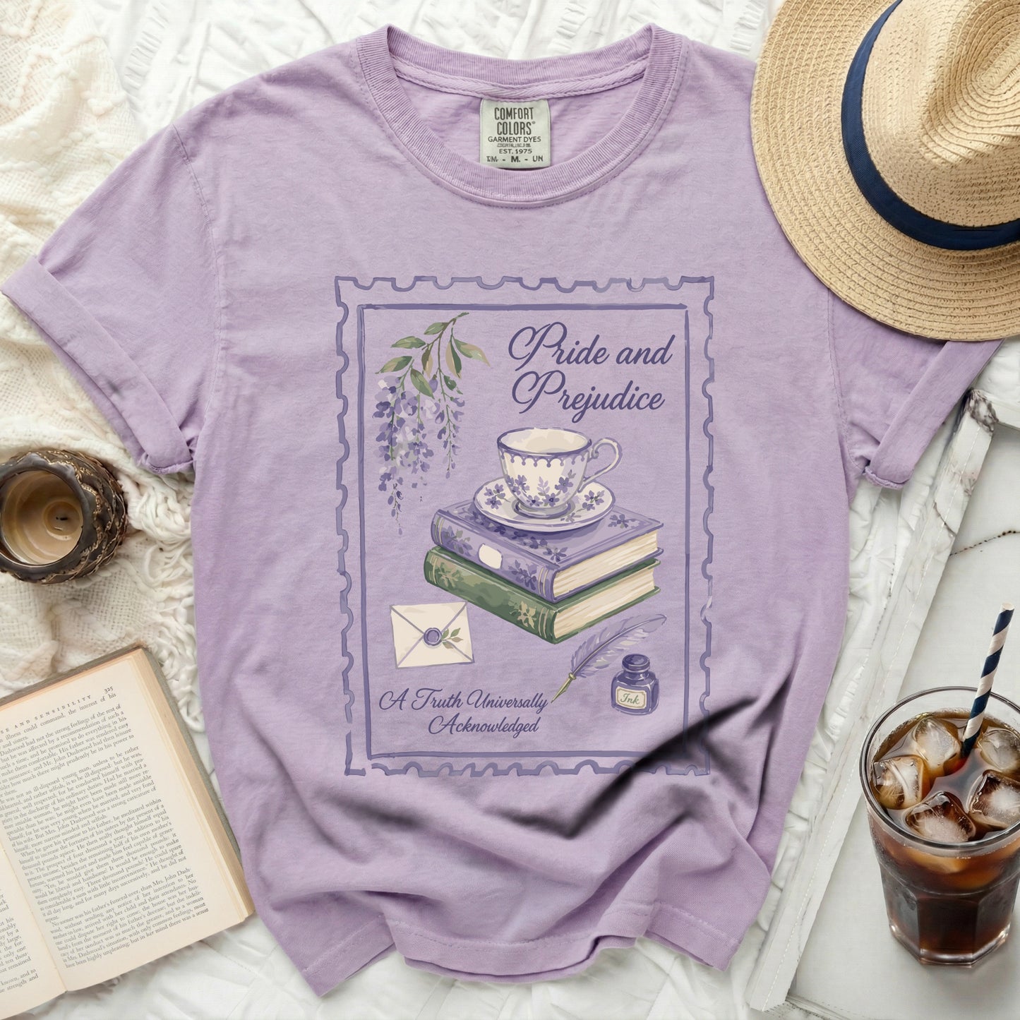 Purple t-shirt with "Pride and Prejudice" design featuring teacup, books, quill, and ink.
