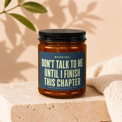 Amber jar candle with dark lid and "Don't talk to me until I finish this chapter" text.