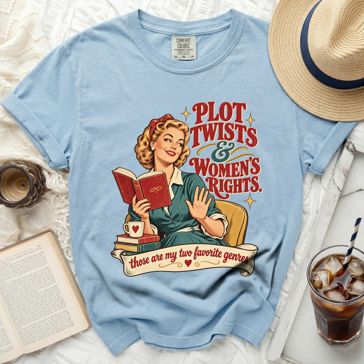 Light blue t-shirt with graphic of woman reading and text "Plot Twists & Women's Rights."