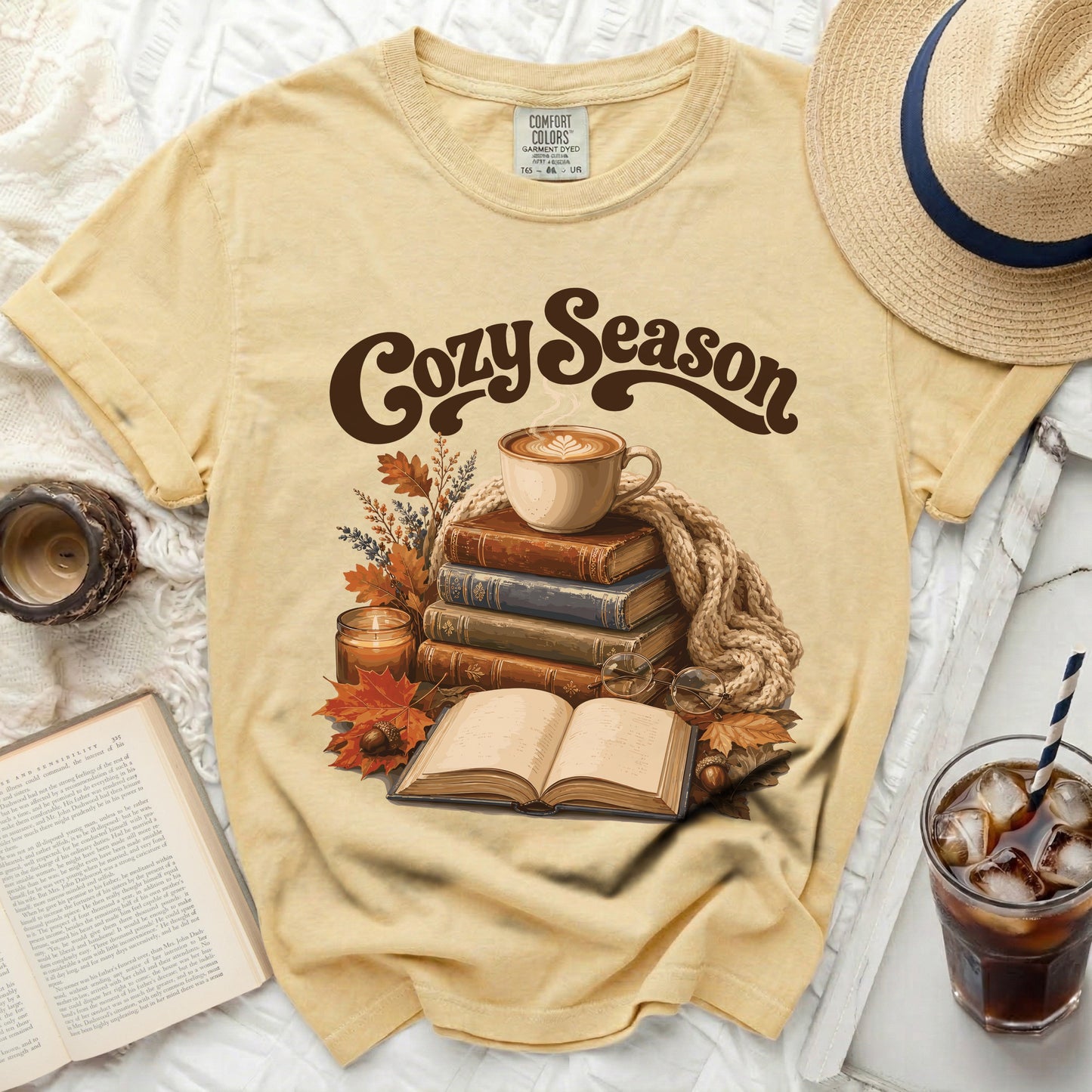 Yellow t-shirt with "Cozy Season" graphic of coffee, books, and fall leaves.