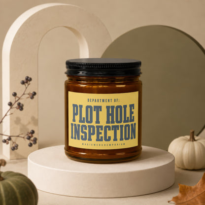 Amber glass candle with "Plot Hole Inspection" text on yellow label.