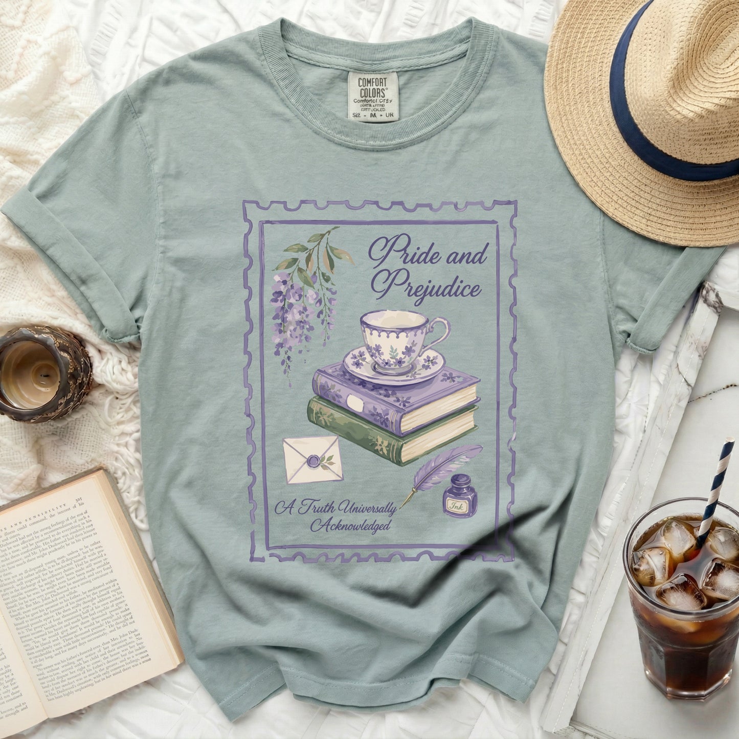 Light sage t-shirt with "Pride and Prejudice" design featuring teacup, books, and flowers.