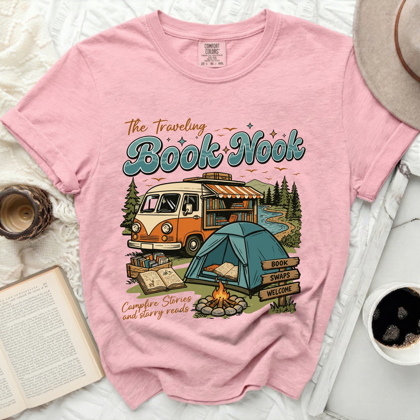 Pink t-shirt with "The Traveling Book Nook" graphic, van, tent, books, and campfire.