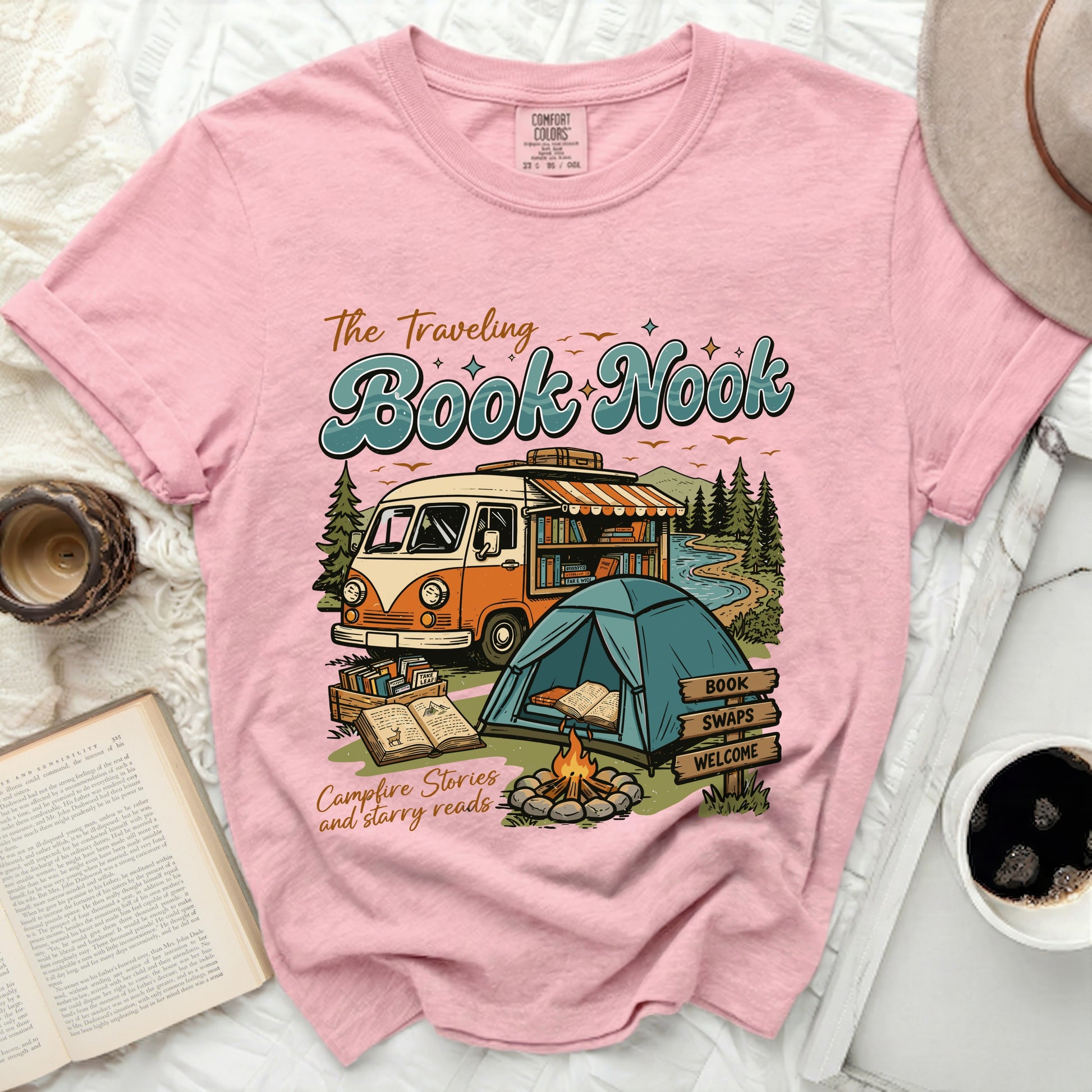 Pink t-shirt with "The Traveling Book Nook" graphic, van, tent, books, and campfire.