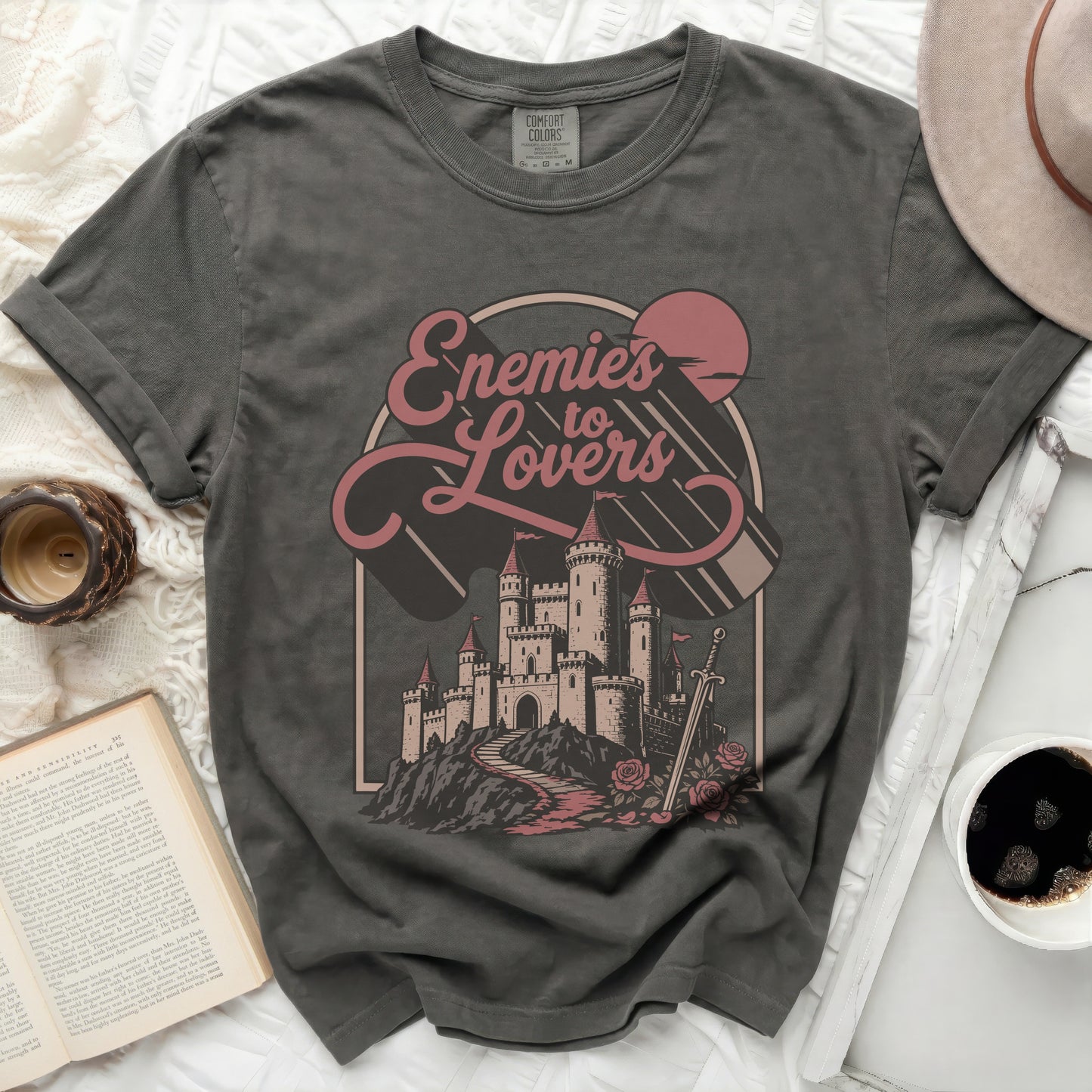 Grey t-shirt with "Enemies to Lovers" text and castle graphic.