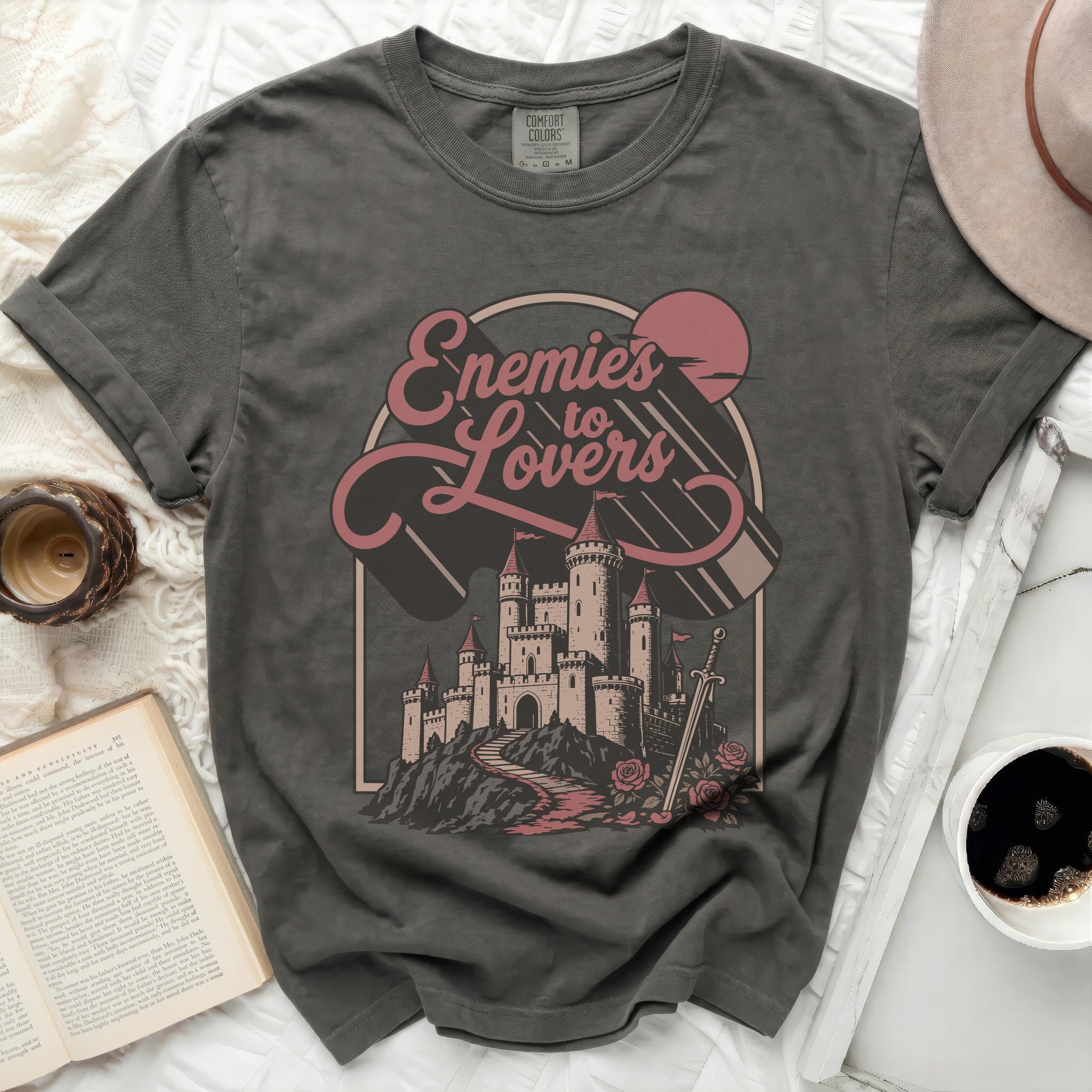 Grey t-shirt with "Enemies to Lovers" text and castle graphic.