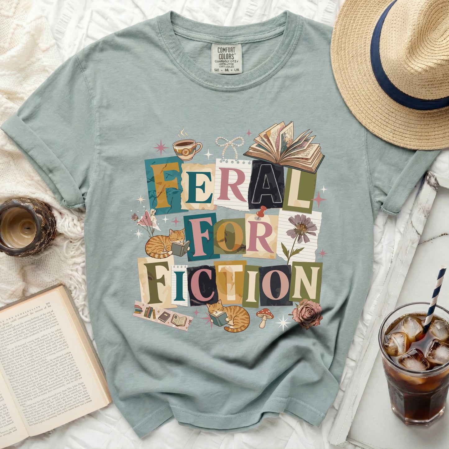 Green t-shirt with "Feral for Fiction" text and cat reading illustrations.