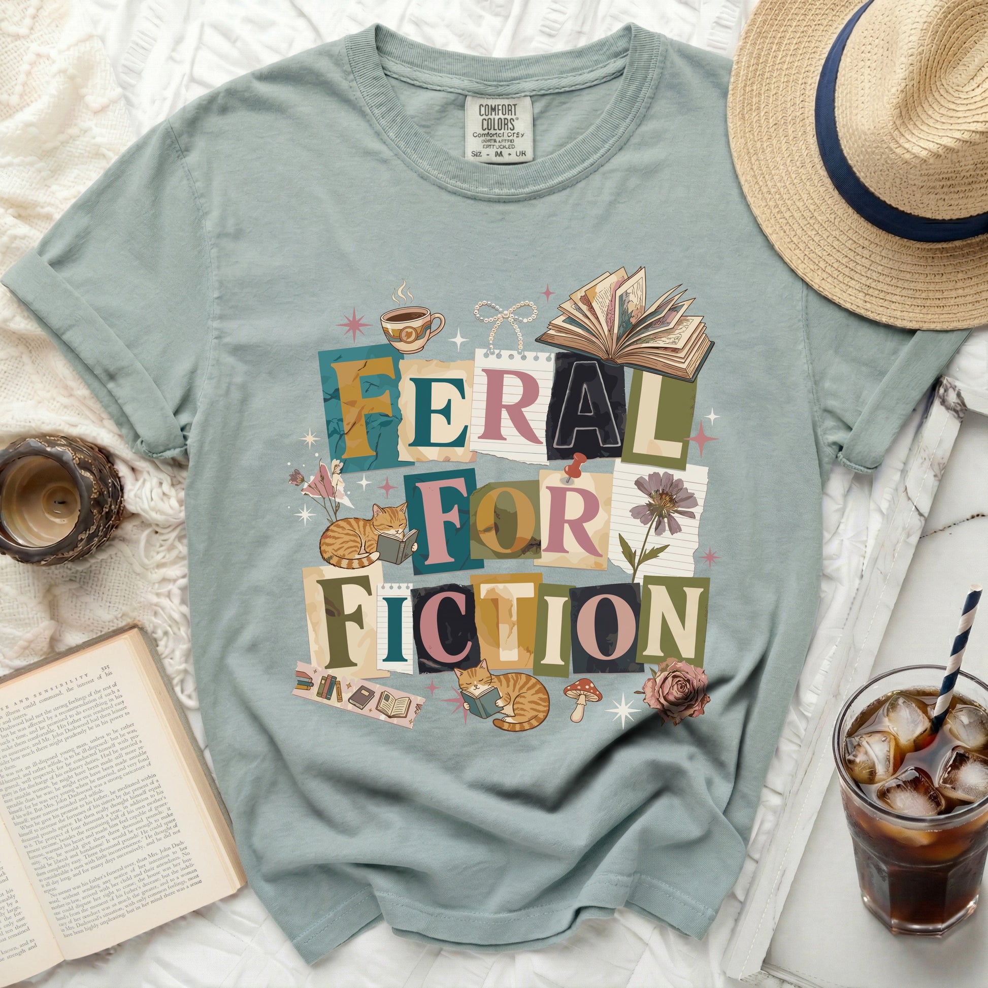 Green t-shirt with "Feral for Fiction" text and cat reading illustrations.