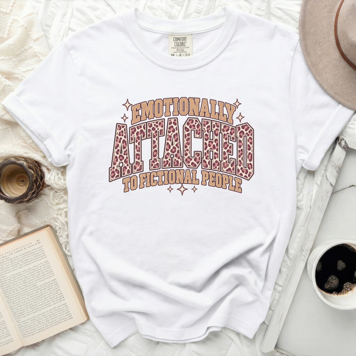 White t-shirt with "Emotionally Attached to Fictional People" leopard print graphic.