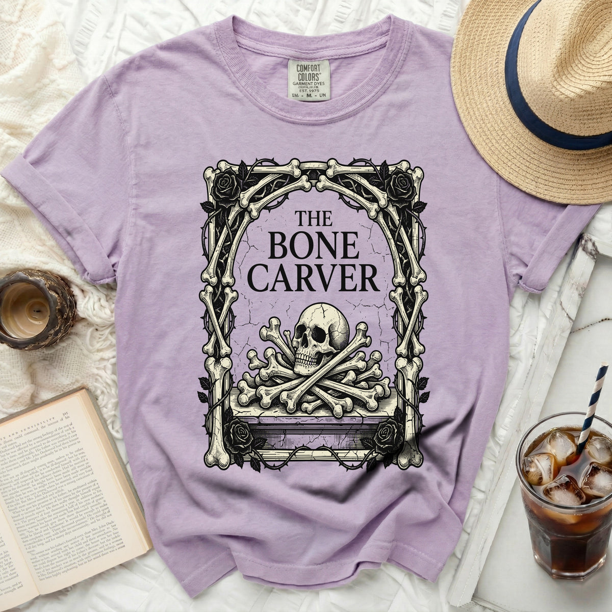 Purple t-shirt with a skull, bones, and roses graphic and "The Bone Carver" text.