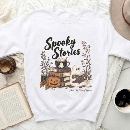 White sweatshirt with "Spooky Stories" and ghost reading among books and pumpkin.
