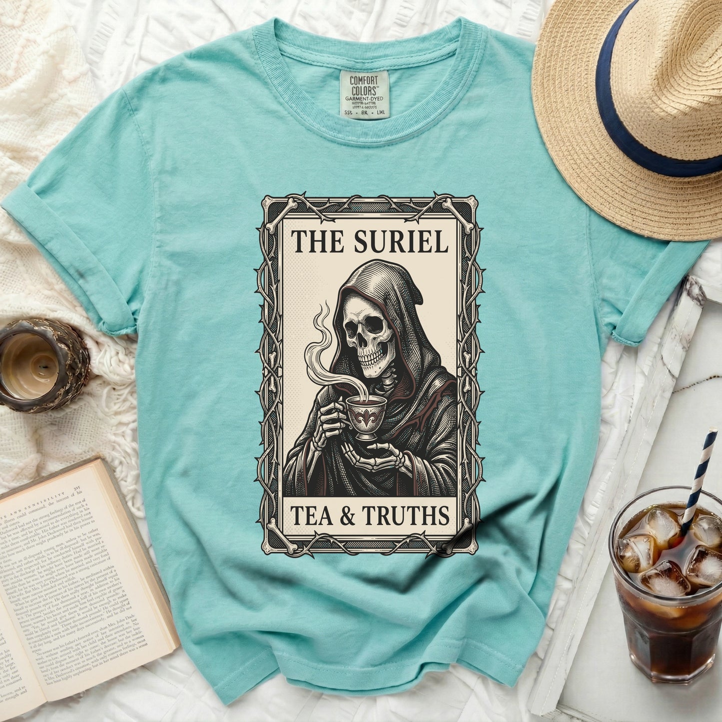 Aqua t-shirt with grim reaper holding cup and text "The Suriel Tea & Truths".