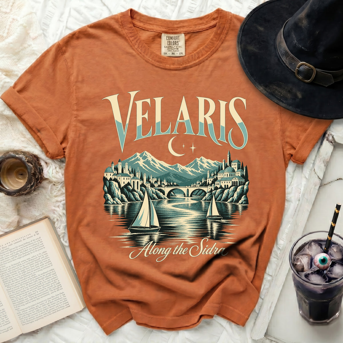 Orange t-shirt with "Velaris Along the Sidra" text and a cityscape.