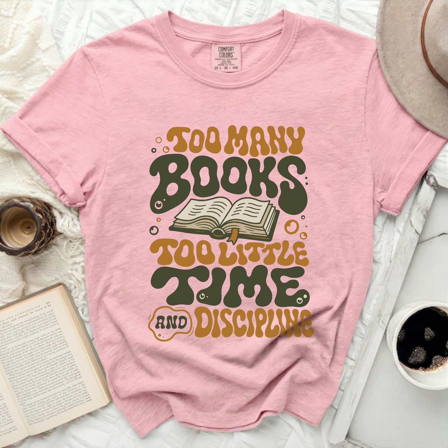 Pink t-shirt with "Too Many Books Too Little Time And Discipline" text.