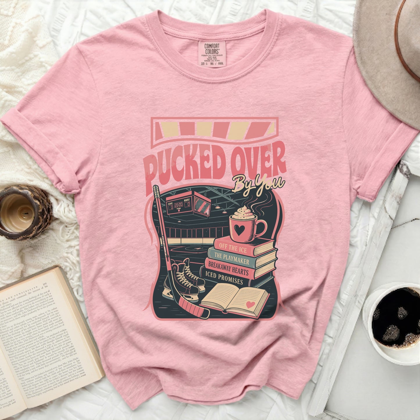 Pink t-shirt with "Pucked Over" text and hockey scene graphic.