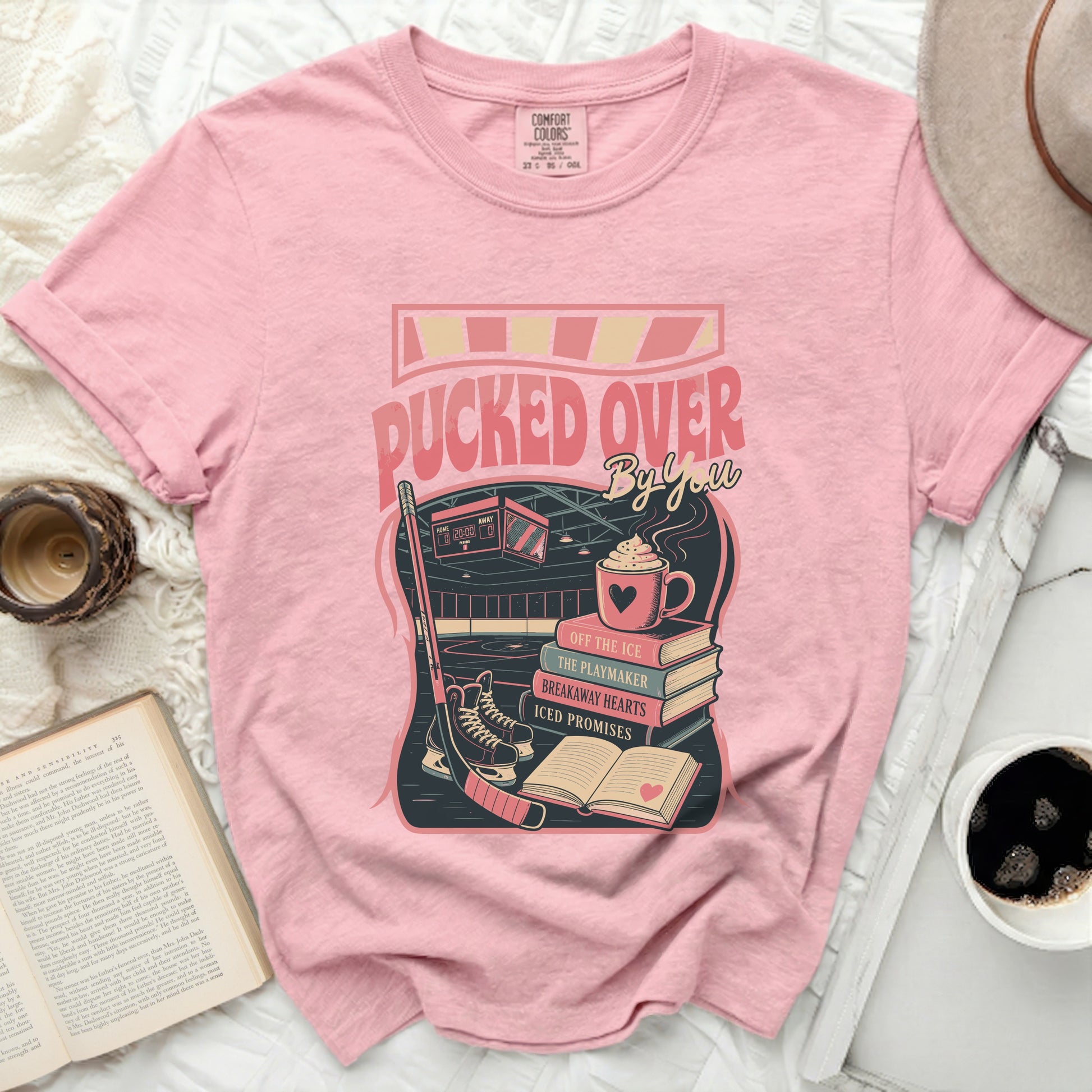 Pink t-shirt with "Pucked Over" text and hockey scene graphic.