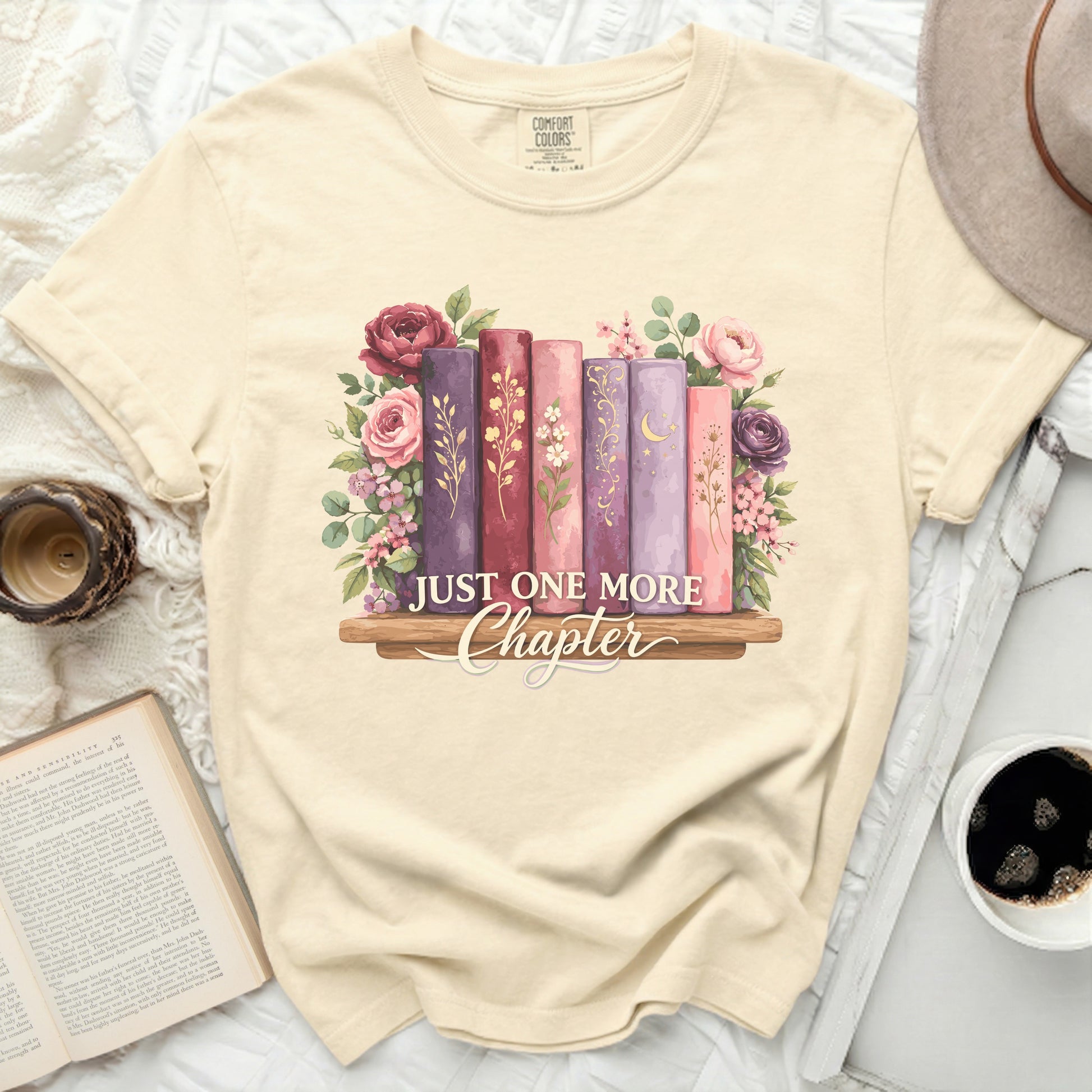 T-shirt with a floral bookshelf design and the text "Just One More Chapter".