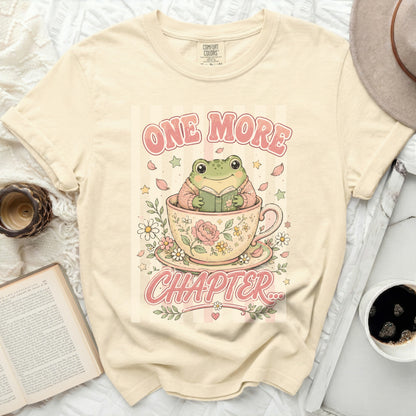T-shirt with frog in teacup reading "ONE MORE CHAPTER" graphic.