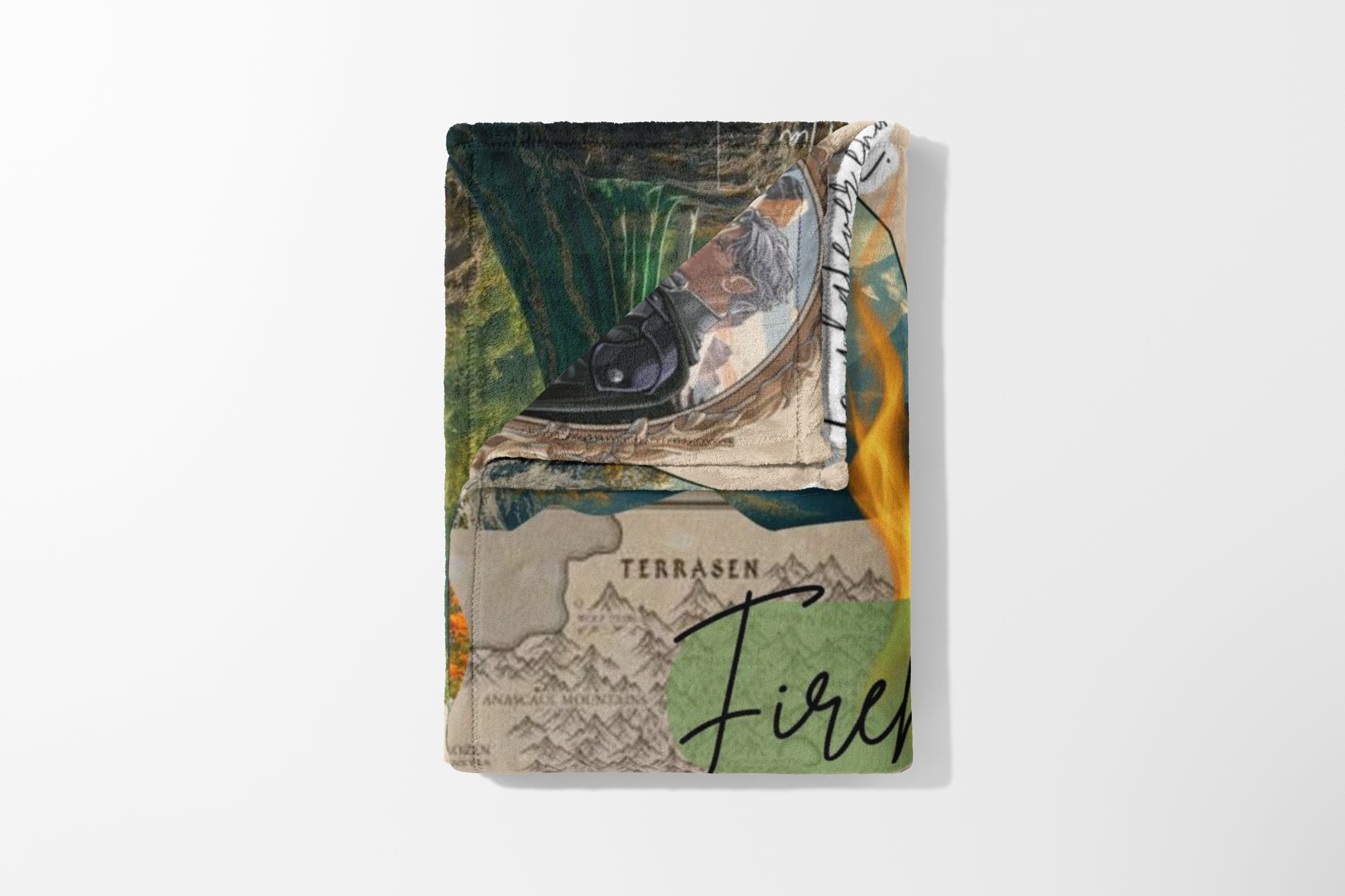 Folded blanket with a fantasy map, mountains, and flames design.