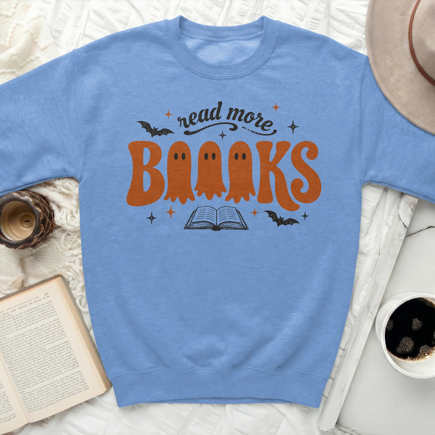 Light blue sweatshirt with "read more Books" ghosts and book design.