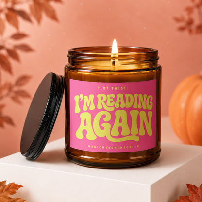 Candle with pink label reading "PLOT TWIST: I'M READING AGAIN"