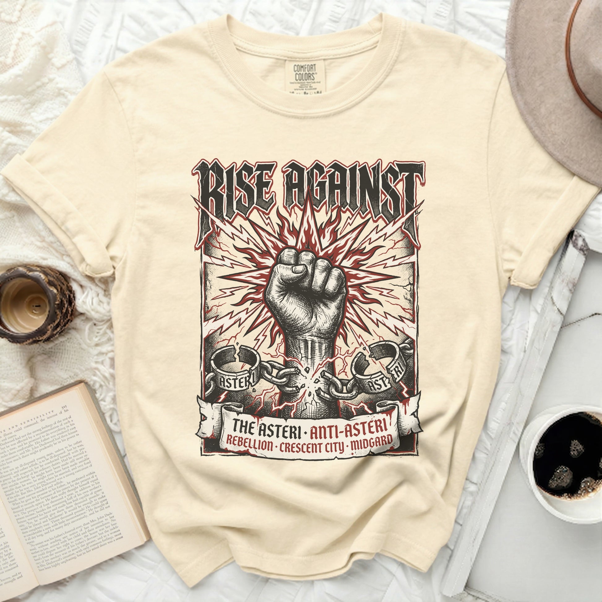 Cream t-shirt with "RISE AGAINST" and a clenched fist graphic.