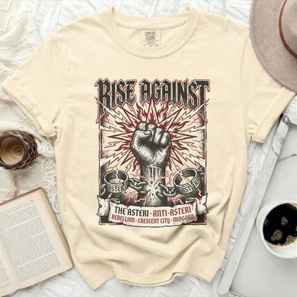 Cream t-shirt with "RISE AGAINST" and a clenched fist graphic.