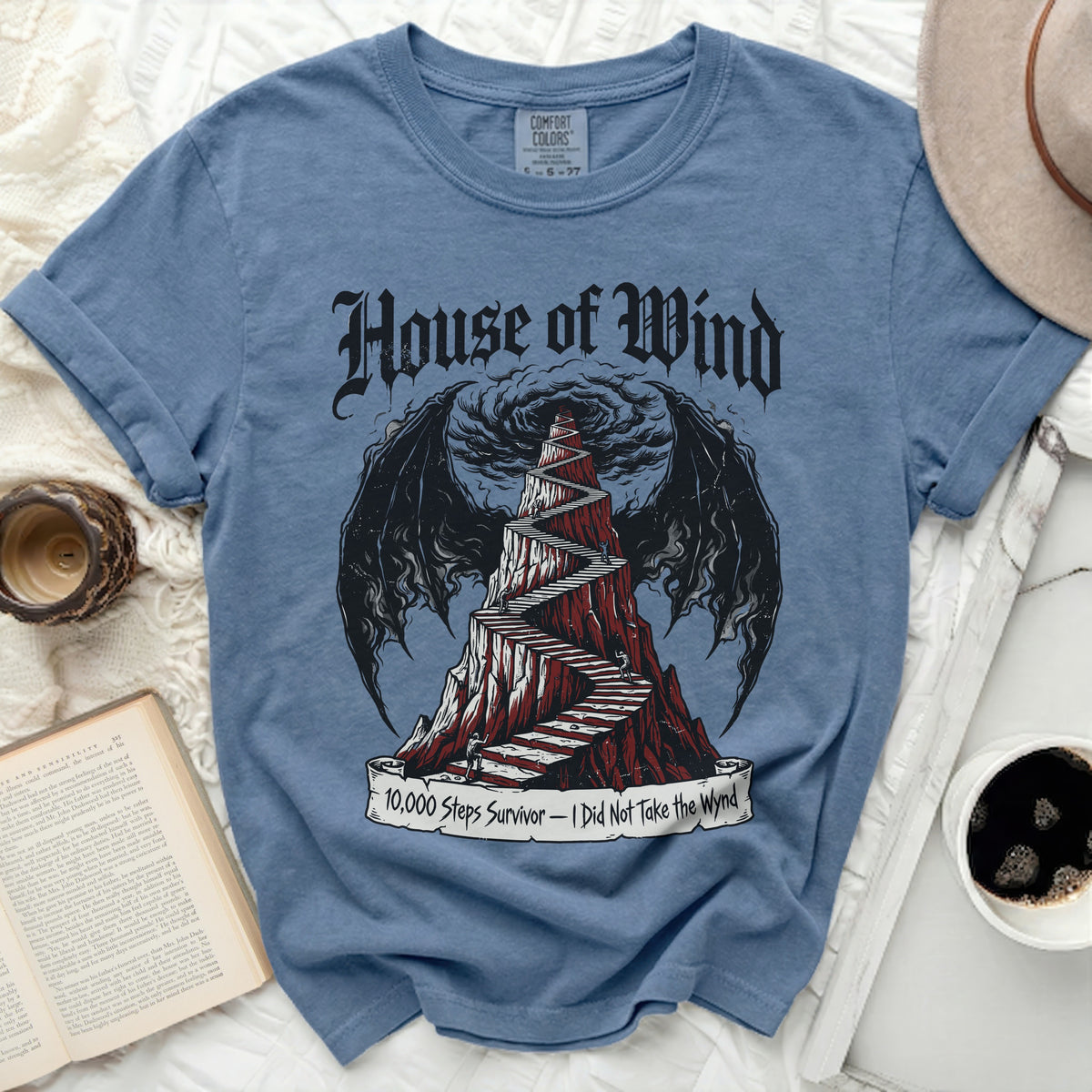 Blue t-shirt with "House of Wind" and winding stairs design.