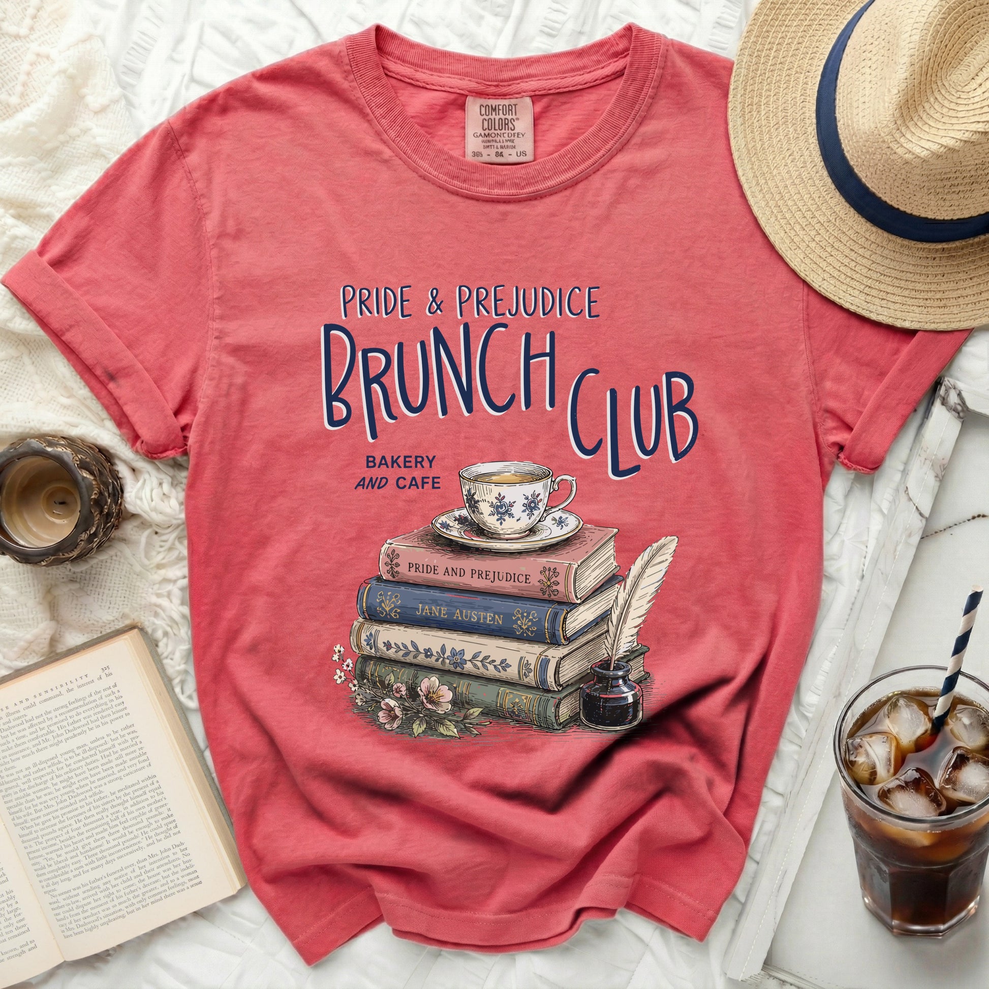 Coral t-shirt with "Pride & Prejudice Brunch Club" graphic and stacked books.