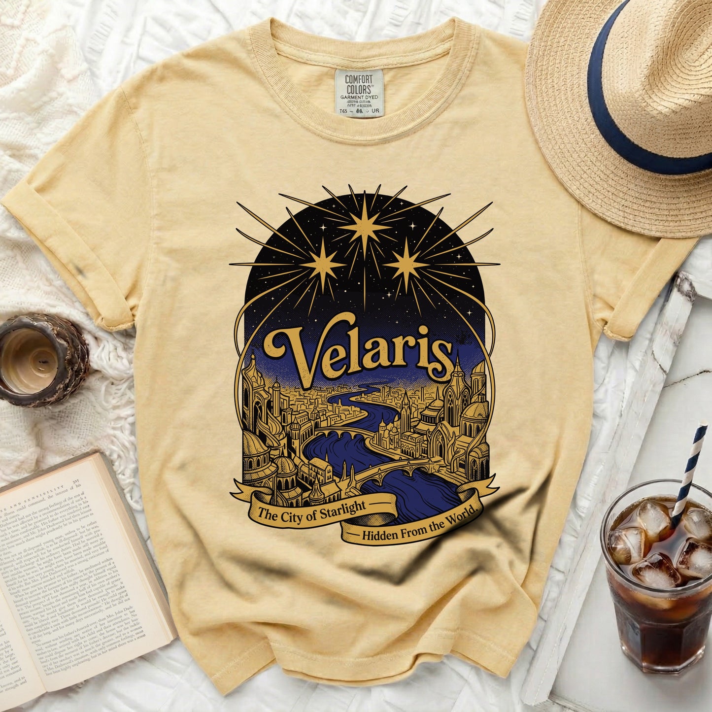Yellow t-shirt with "Velaris The City of Starlight Hidden From the World" graphic.