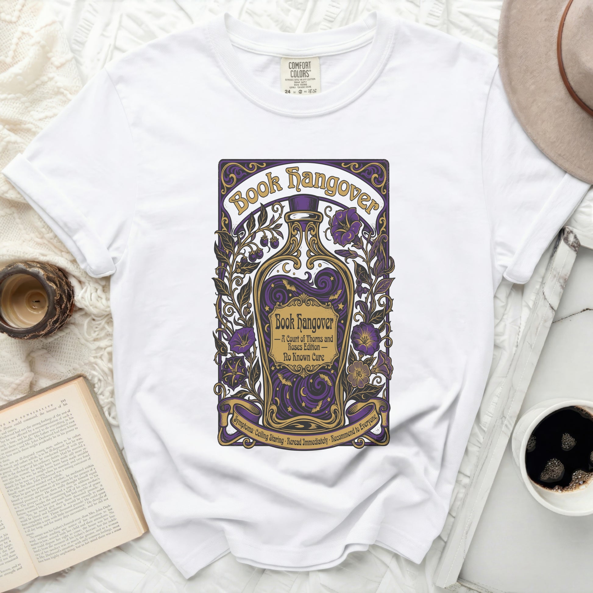 White t-shirt with "Book Hangover" graphic in purple and gold.