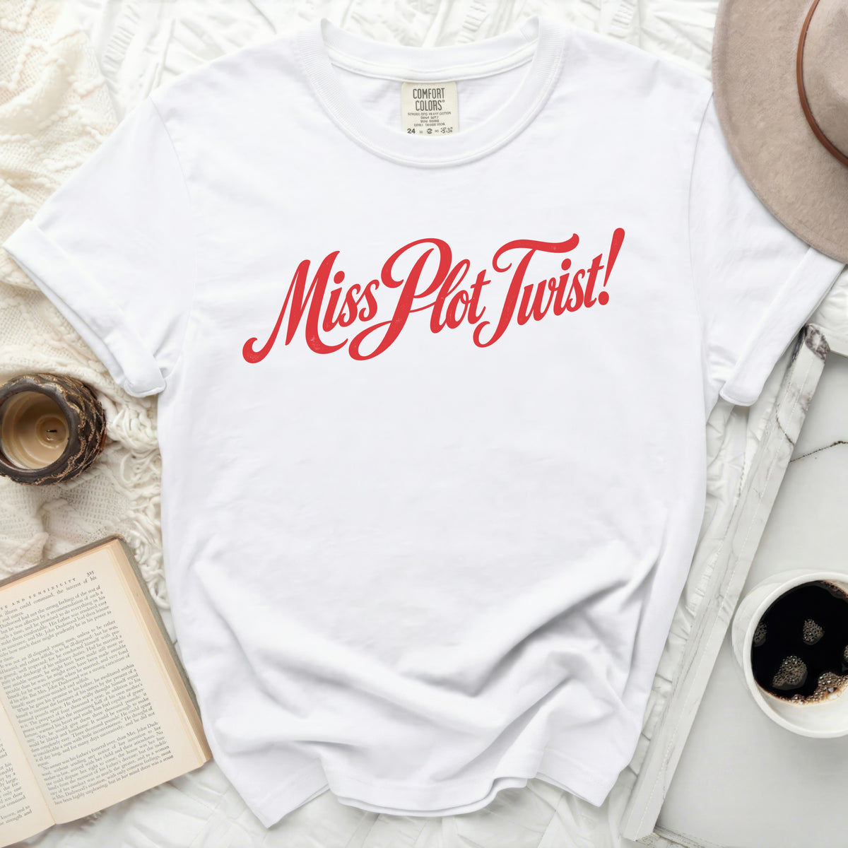 White t-shirt with red "Miss Plot Twist!" graphic.