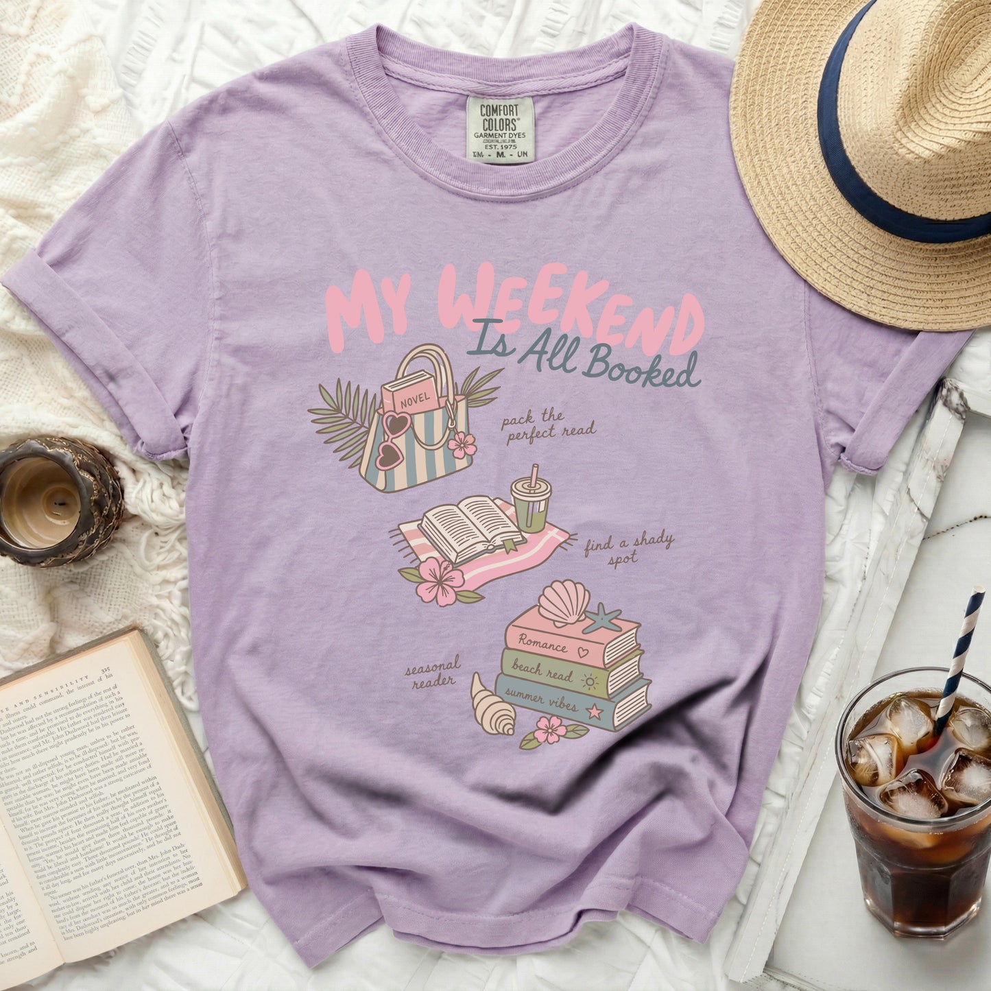 Graphic tee with text "My Weekend Is All Booked" and book-related illustrations.