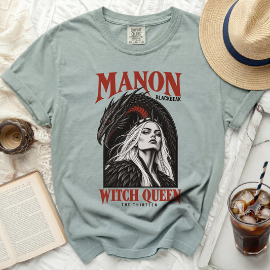 Light blue t-shirt with "Manon Blackbeak Witch Queen The Thirteen" graphic.