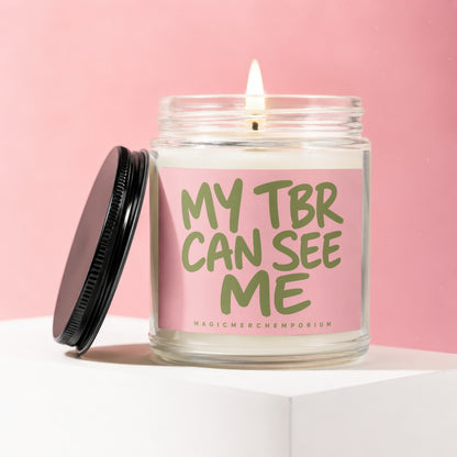 Lit candle in glass jar with pink label that reads "MY TBR CAN SEE ME".
