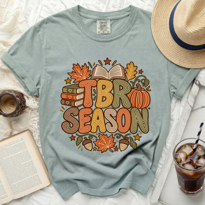 Light blue t-shirt with "TBR SEASON" autumn-themed graphic and an open book.