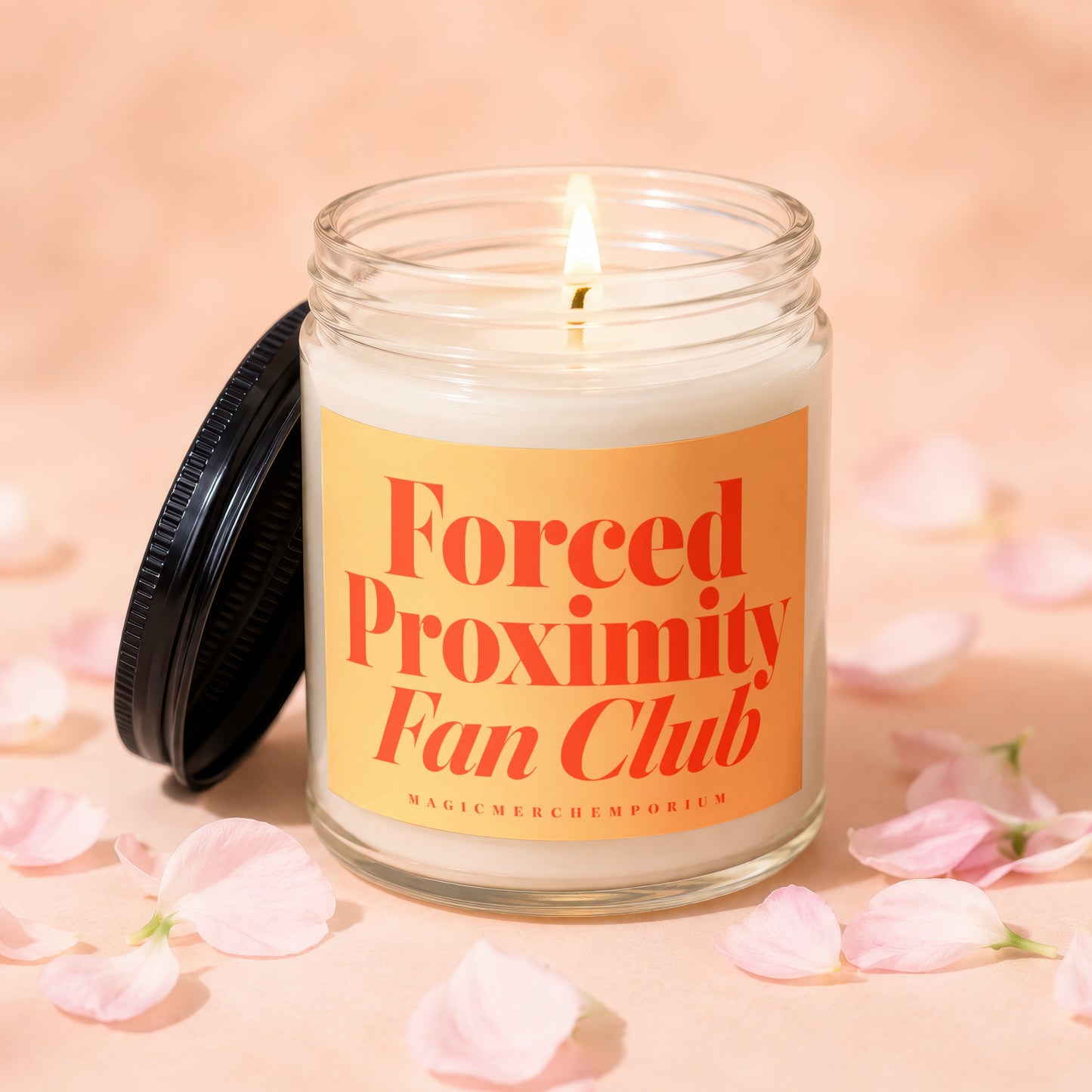 Lit candle in glass jar with "Forced Proximity Fan Club" label and scattered petals.