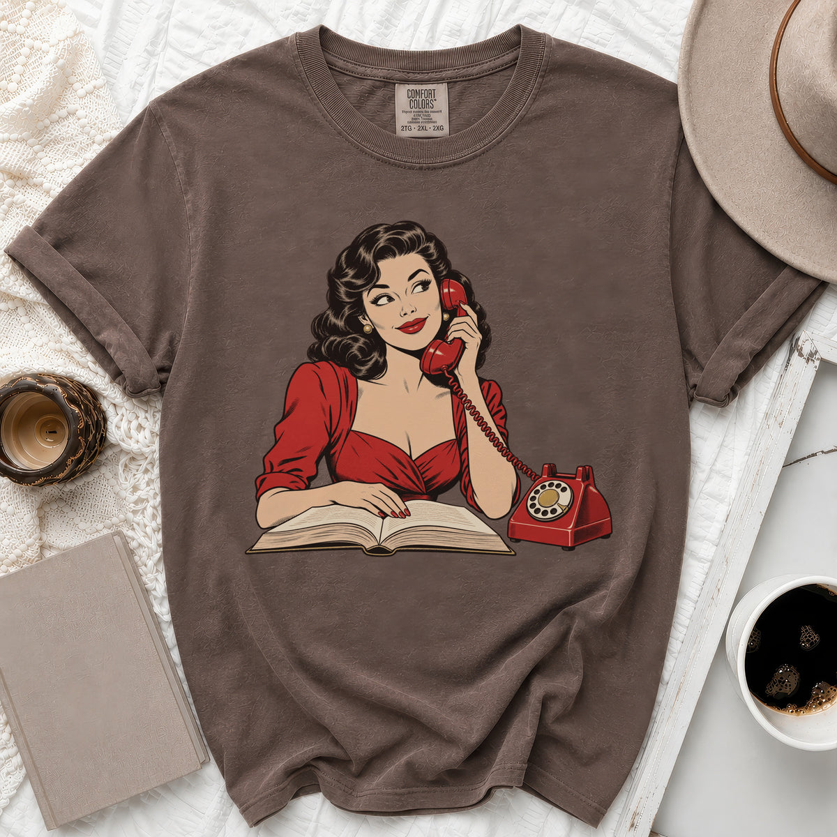 T-shirt with graphic of woman on phone reading a book.