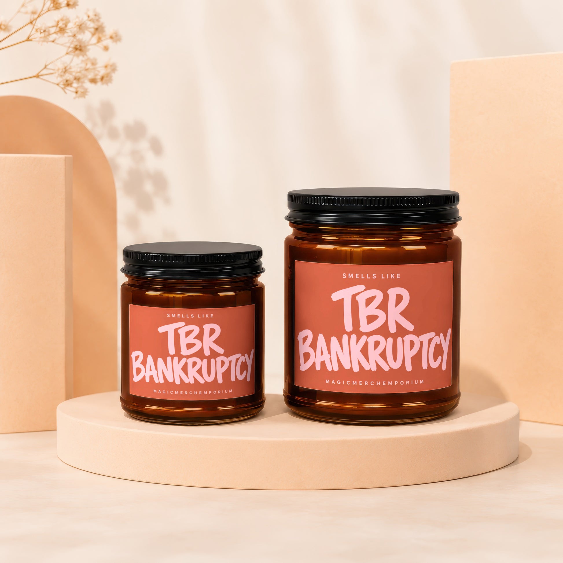 Two amber glass jars with black lids, labeled "Smells Like TBR Bankruptcy".