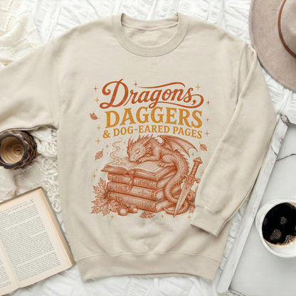 Cream sweatshirt with "Dragons, Daggers & Dog-Eared Pages" graphic.