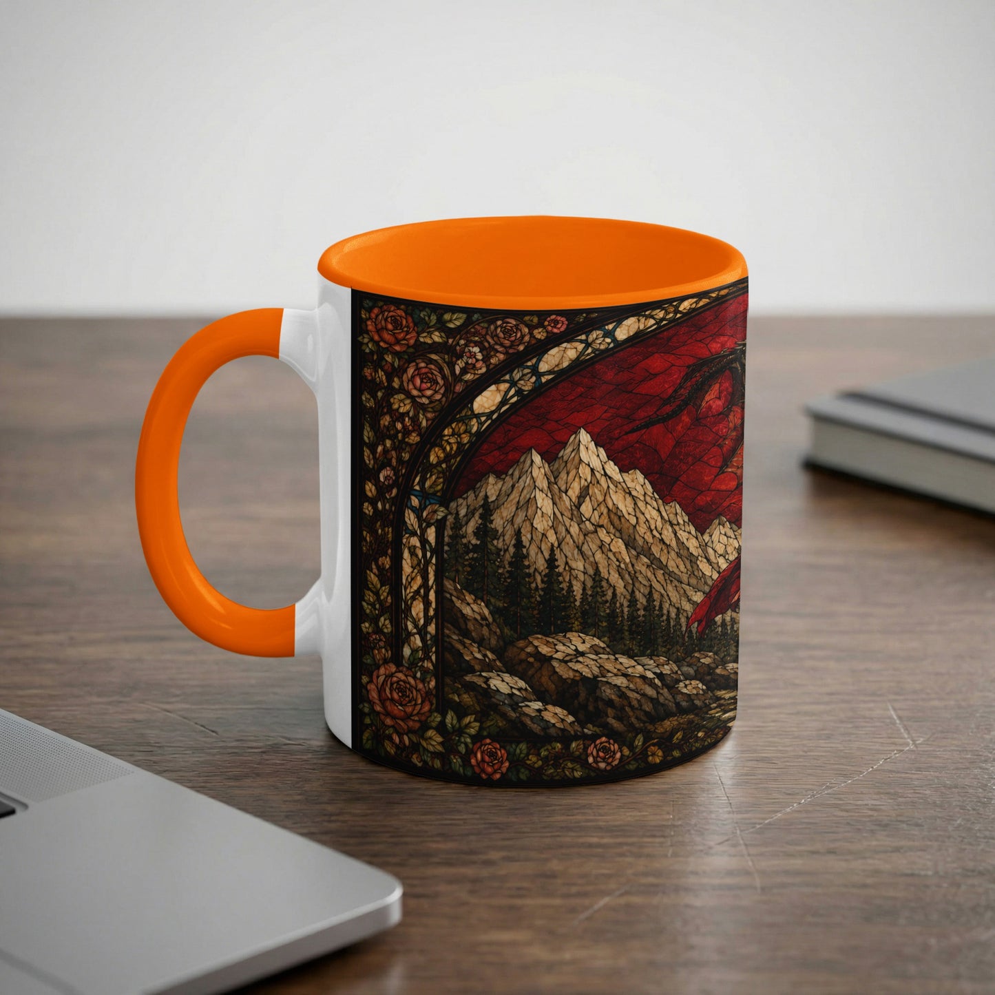 White mug with orange handle featuring stained glass art of a dragon and mountains.