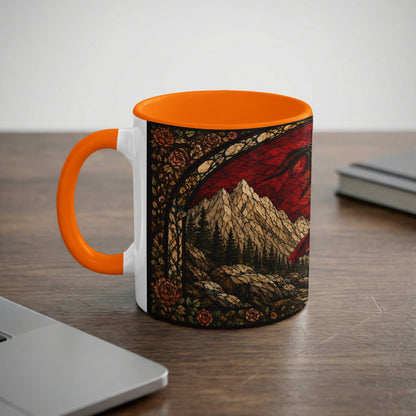 White mug with orange handle featuring stained glass art of a dragon and mountains.