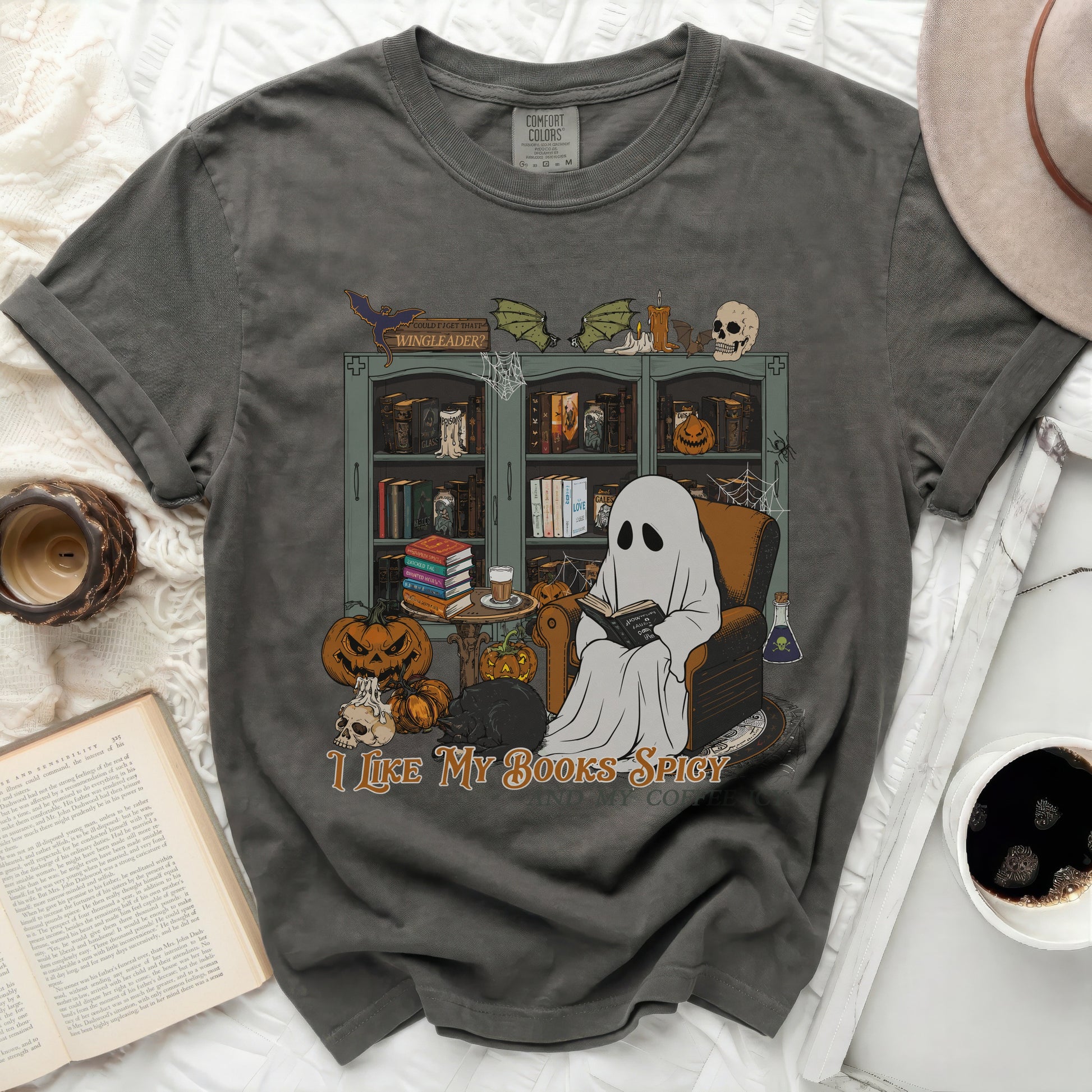 Ghost reading book with Halloween decorations and text "I LIKE MY BOOKS SPICY".